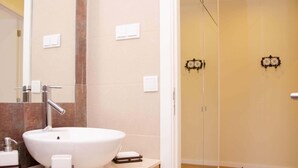 A bathroom with a large white sink, a mirror, and a shower area. - Porto Histórico 4 - Superior one bedroom apartment (Porto)