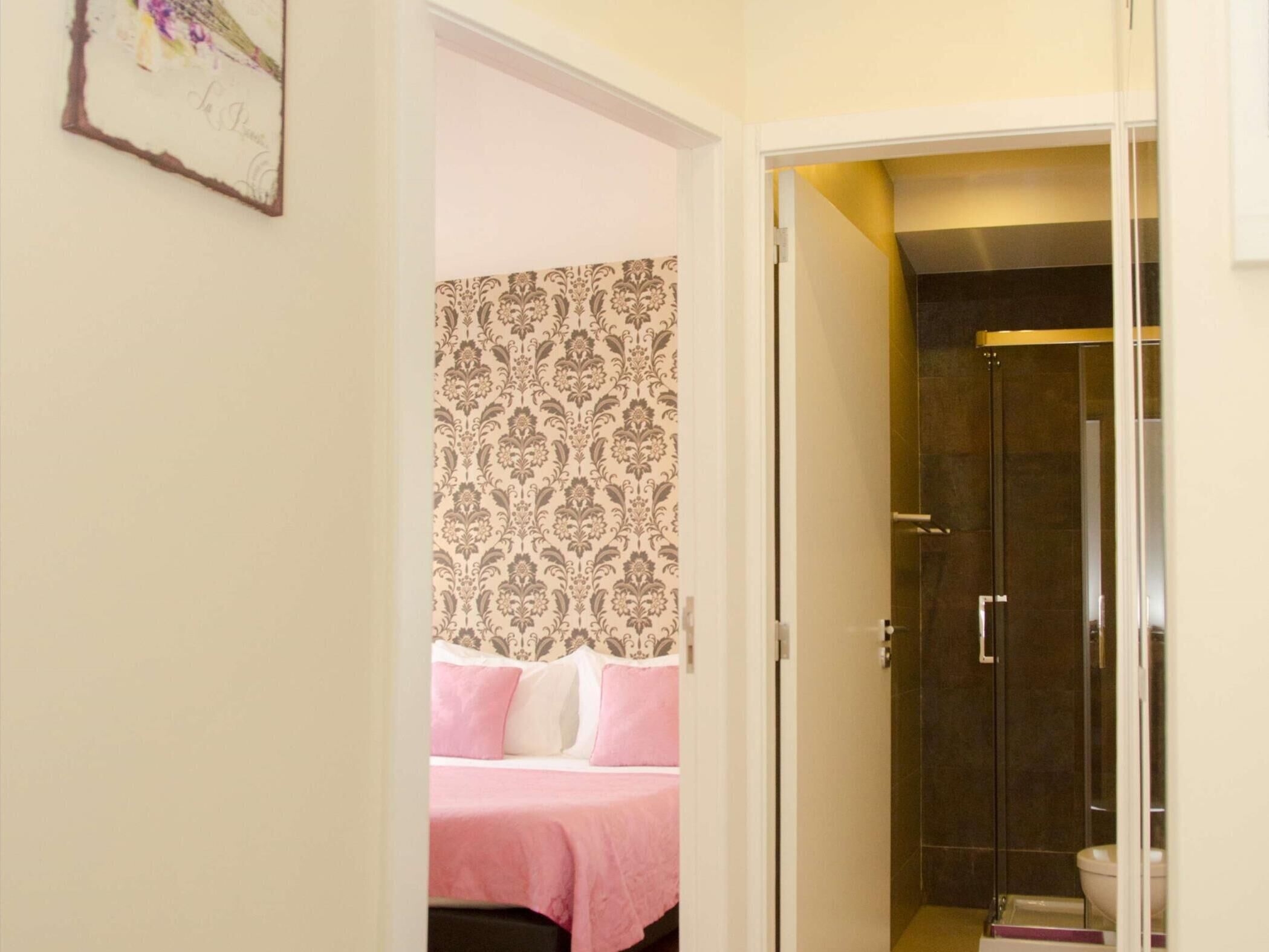 A bedroom with a bed, a shower, and a bathroom.