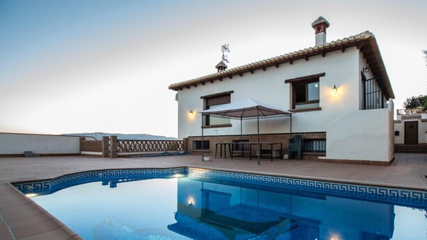 Ein modernes Haus mit Schwimmbad, Terrasse und überdachter Sitzgelegenheit im Freien.