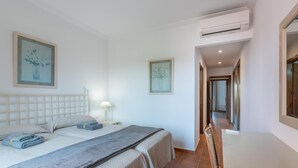 Une chambre d’hôtel avec un lit, une table de chevet, une lampe et deux tableaux encadrés au mur.