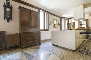A kitchen with a wooden cabinet, a sink, and a bar stool. - UR-NEST Guerrazzi Deluxe (Bologna)