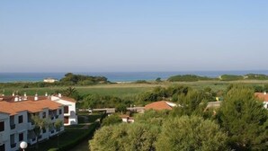 A coastal view with buildings and greenery. - 2 Bedroom Apartment , Son Bou (Son Bou)