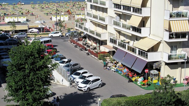 Un immeuble à plusieurs étages doté de balcons donnant sur une plage.