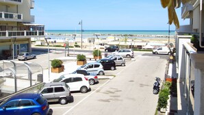 Un parking avec plusieurs voitures et une vue sur la plage.