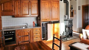 Una cocina con gabinetes de madera, estufa y lavavajillas.