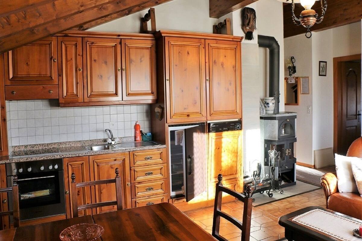 Ett kök med träskåp, en spis och en diskmaskin.