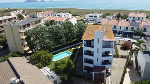 Zona residencial con edificios modernos, piscina y vista al mar.