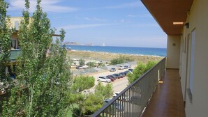 Un balcon donnant sur un parking et une plage.