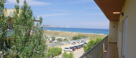 Un balcón con vista a un estacionamiento y a la playa.
