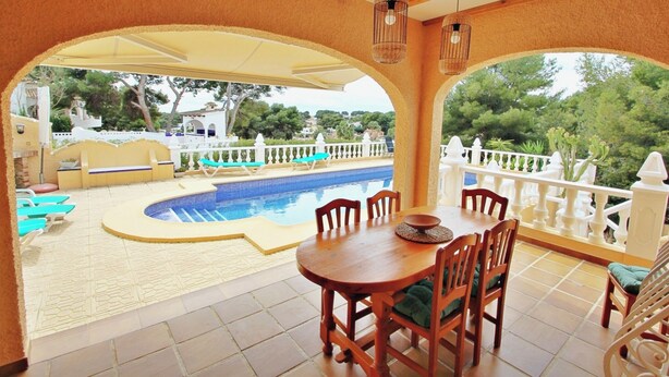 A covered outdoor area with a pool, wooden furniture, and a white railing. - Sofia - holiday home with private swimming pool in Moraira (Teulada)