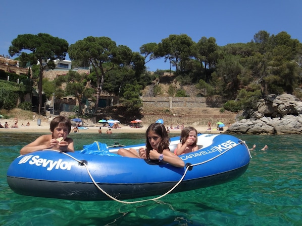 A blue inflatable raft with "Sevylor" and "Caravelle" written on it, floating on clear water.