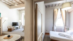 Un dormitorio con cama, mesita de noche y cortinas.