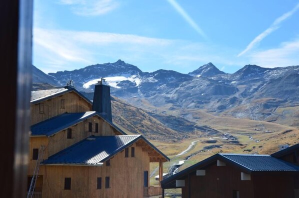 A wooden building with a metal roof, surrounded by mountains and a winding road. - Apartment/ flat - VAL THORENS (Val Thorens)