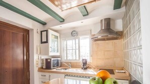 Una cocina con encimera de madera, microondas, fregadero y ventana con vistas.