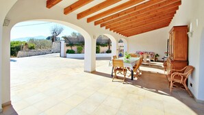An open patio with a wooden ceiling, a dining table with chairs, and a view of the outdoors. - Finca La Verema - holiday home with private swimming pool in Benissa (Benissa)