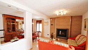 A living room with a fireplace, a sofa, and a dining area with wooden furniture. - Finca La Verema - holiday home with private swimming pool in Benissa (Benissa)
