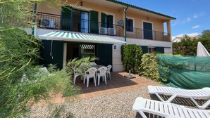 A two-story building with a balcony, outdoor seating, and a covered patio area. - Daró 3D 37 - A/C, pool and 150m from the beach (Torroella de Montgri)