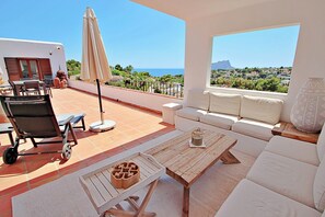 A terrace with a sofa, a wooden table, and a chair. - Argentario - sea view villa with private pool in Benissa (Benissa)