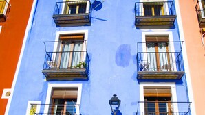 A multi-story building with balconies, a door, and a lamp post.