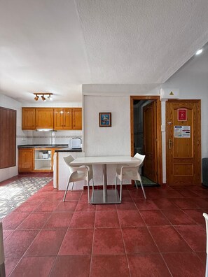 A compact kitchen with wooden cabinets, a white countertop, and a stainless steel range hood. - ARSENAL 2 - 2 HABITACIONES CON VISTAS AL MAR (Villajoyosa)