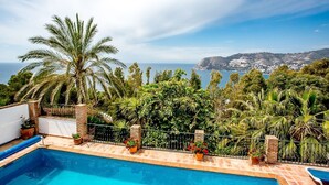 Una piscina con vistas al mar y a las montañas.