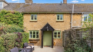 A stone cottage with a green door, multiple windows, and a small porch area. - Forsythia Cottage - sleeps 3 guests  in 2 bedrooms (Bourton-on-the-Water)