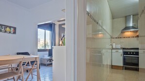 Una cocina moderna con gabinetes blancos, una campana extractora de acero inoxidable y un horno empotrado.