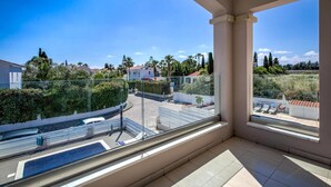 A balcony with a clear view of a residential area, including houses and greenery. - Villa Crystal by Ezoria Villas (Coral Bay)