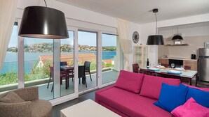En moderne lejlighed med balkon, spiseområde og køkken.