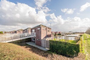 Un quartiere residenziale con case, un ponte e un sentiero che conduce all'acqua.