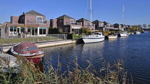 Un canal con barcos, casas y cielo despejado.
