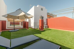 Relax in style with a comfortable lounge area, complete with a green lawn and two lounge chairs.