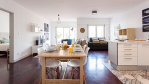 A modern, well-lit living space with a dining area, kitchen, and seating area. - JOIVY Stunning apt near Avenida da Liberdade (Lisboa)