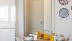 A breakfast table set with bowls, cups, and a pitcher of orange juice. - JOIVY Stunning apt near Avenida da Liberdade (Lisboa)