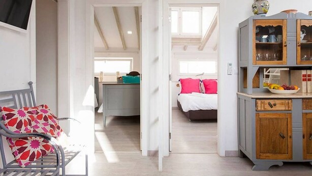 A room with a bed, a desk, a chair, and a cabinet.