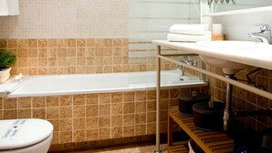 Ein Badezimmer mit Badewanne, Toilette, Waschbecken und Spiegel.