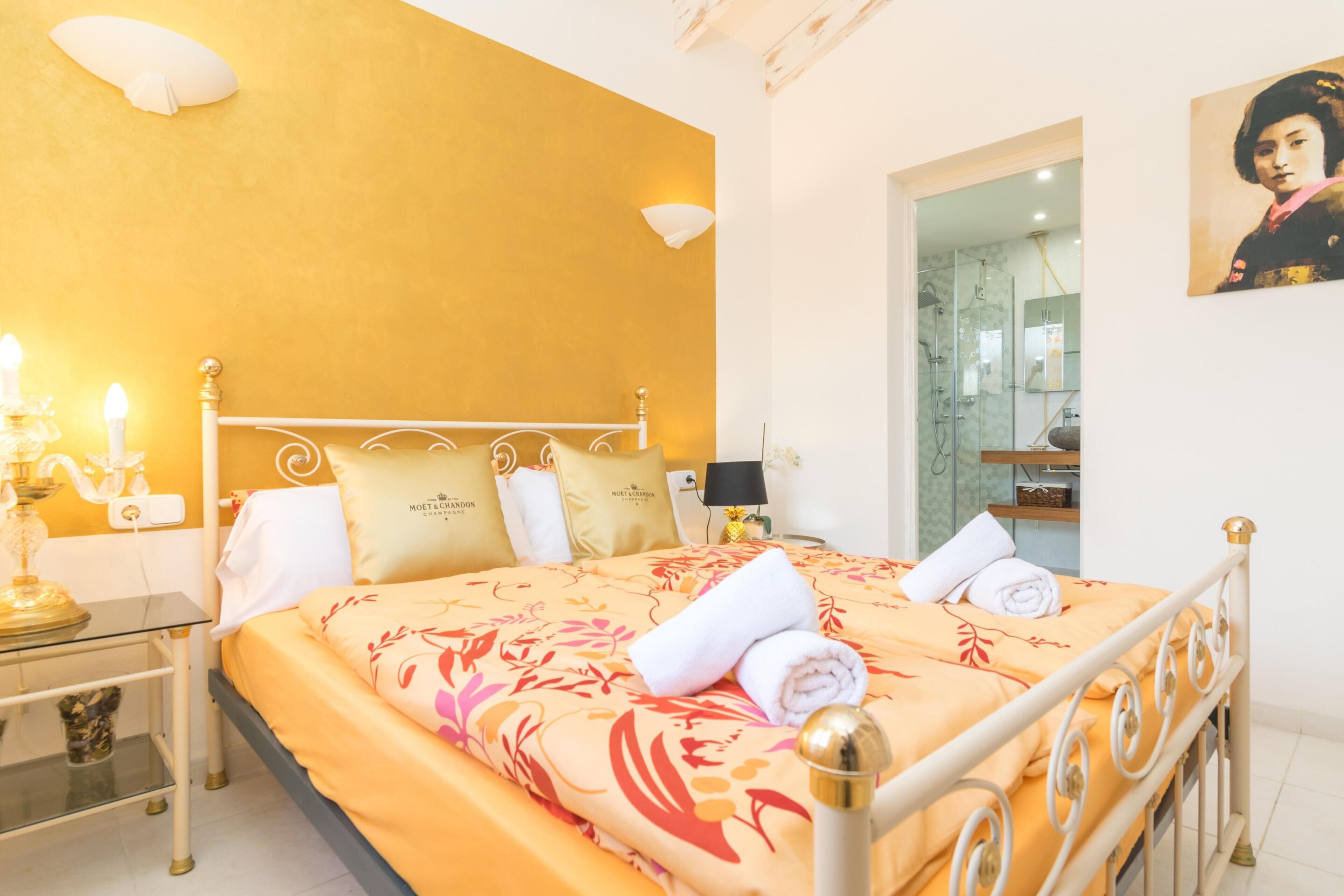 Ein Hotelzimmer mit Bett, Nachttisch, Lampe und einem Bild an der Wand.