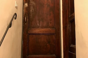 A wooden door with a metal handle and a metal latch.