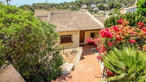 A residential area with terracotta-tiled roofs, a small building with a window, and lush greenery including flowering plants. - Kanky 10 - family-friendly holiday house in Benissa (Benissa)