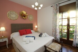 Une chambre d’hôtel avec un grand lit, deux tables de chevet avec des lampes, des éléments décoratifs fixés au mur et une fenêtre avec des rideaux.