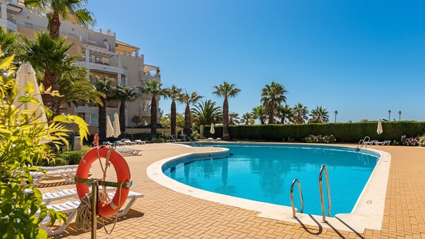 A swimming pool with sun loungers, a lifebuoy, and palm trees. - Las Dunas - Punta del Moral Beach PLHD145P118 (Punta del Moral)