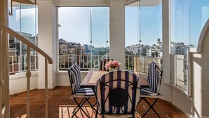 A balcony with a table and chairs, a flower vase, and a city view. - Las Dunas - Punta del Moral Beach PLHD145P118 (Punta del Moral)