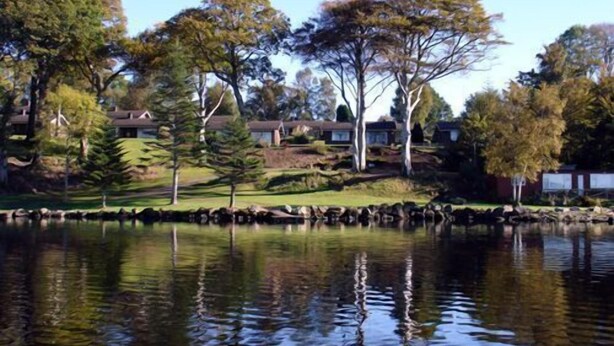 A residential area with houses, trees, and a body of water reflecting the surroundings. - Cottage 5 -  a cottages  that sleeps 6 guests  in 0 bedrooms (Irvinestown)
