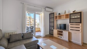 Ein modernes Wohnzimmer mit einer Couch, Fernseher und Einbauschränken.