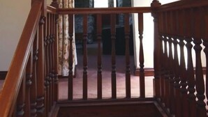 A wooden staircase with a handrail leading to an upper floor.