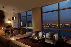 Uma sala de estar moderna com vista para a cidade, uma cozinha com banquetas e uma janela grande.