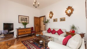 A living room with a sofa, coffee table, TV, and decorative items. - Ancient Rome View Apartment (Rome)
