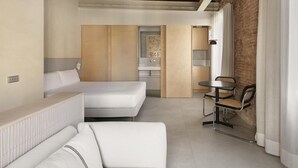 A modern hotel room with a bed, a sofa, a small dining table, and a kitchen area. - Studio with terrace in Born (Barcelona)