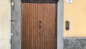 A wooden door with a metal handle, a number '32' sign above it, and a small vent on the wall to the right. - Large and completely refurbished apartment with a beautiful patio. (Firenze)