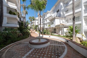 Stroll through the serene courtyard, surrounded by lush greenery and palm trees, and enjoy the tranquil atmosphere.
